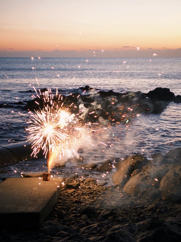 Sparks glowing beside the sea at dusk